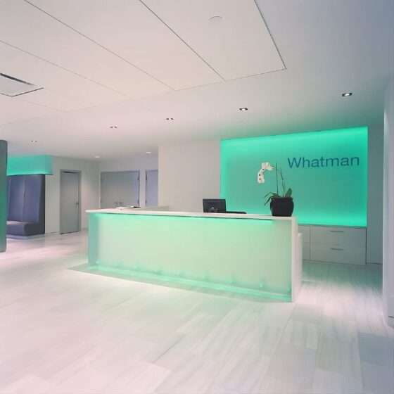 Reception area of the Whatman U.S. Headquarters in Florham Park, New Jersey, featuring custom glass walls and integrated LED lighting, completed by Advance Realty.