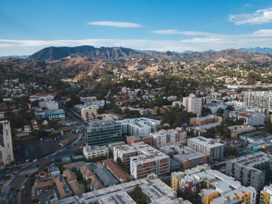 Aerial view of downtown Los Angeles showing buildings, streets, and city skyline under clear skies.